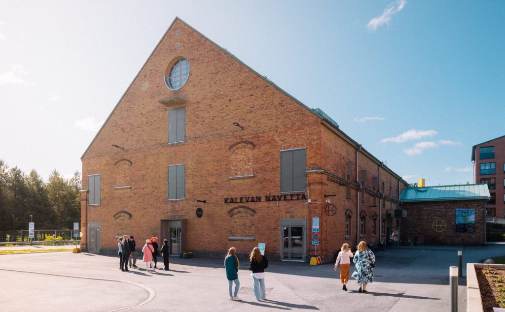 tiilirakennus jotak ohti ihmiset kävelevät kesäisenä päivänä