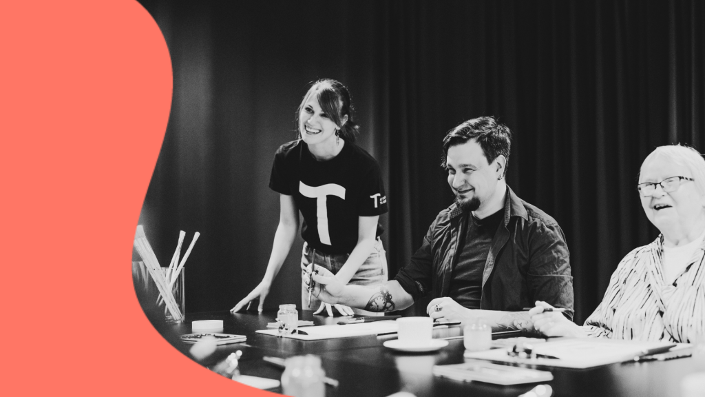 People sitting around a table and painting with watercolors.