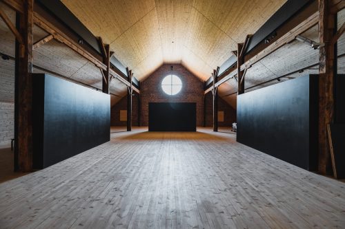 Vintti exhibition space, wooden floor and ceiling, wooden beams, circular window